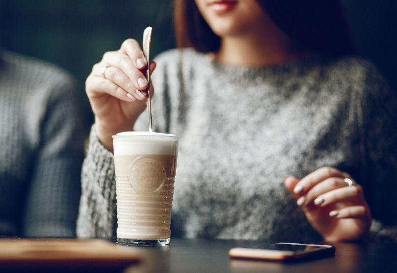 woman-having-a-drink-in-a-cafe